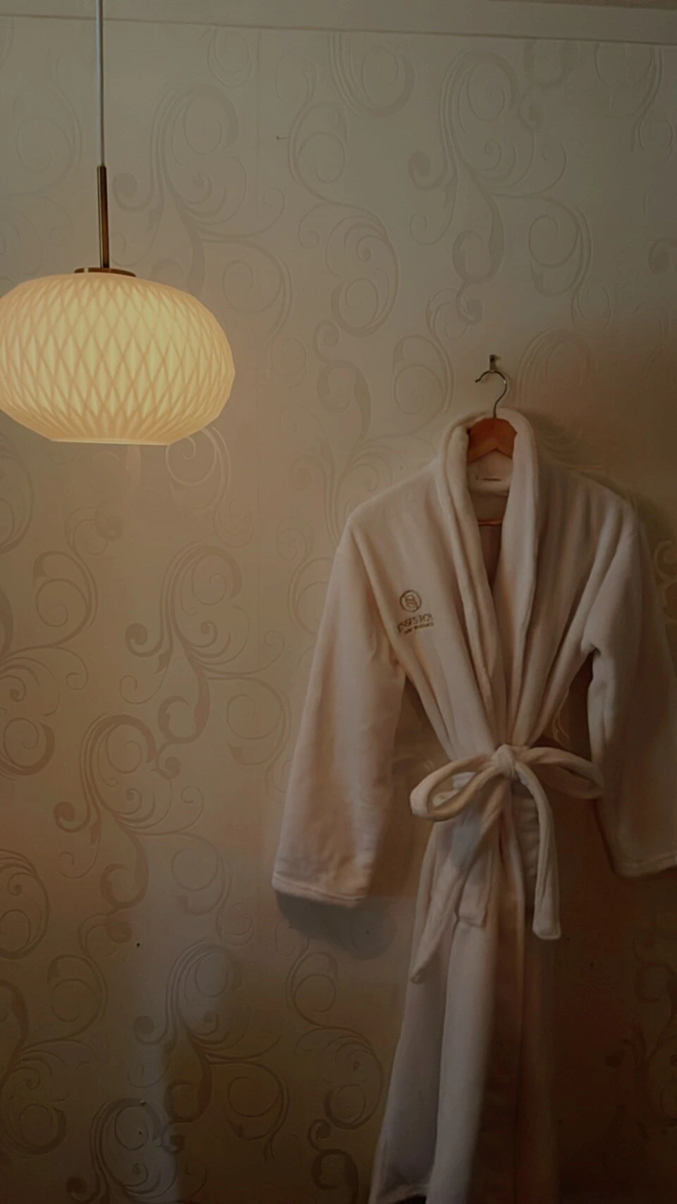 Senses spa robe beneath a softly lit pendant